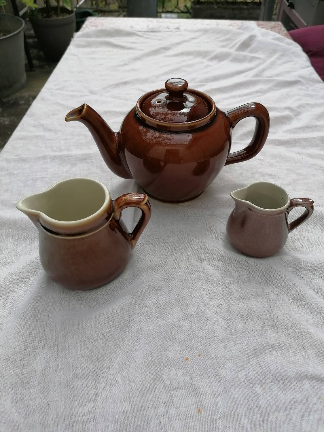 Brown ceramic teapot and milk jugs