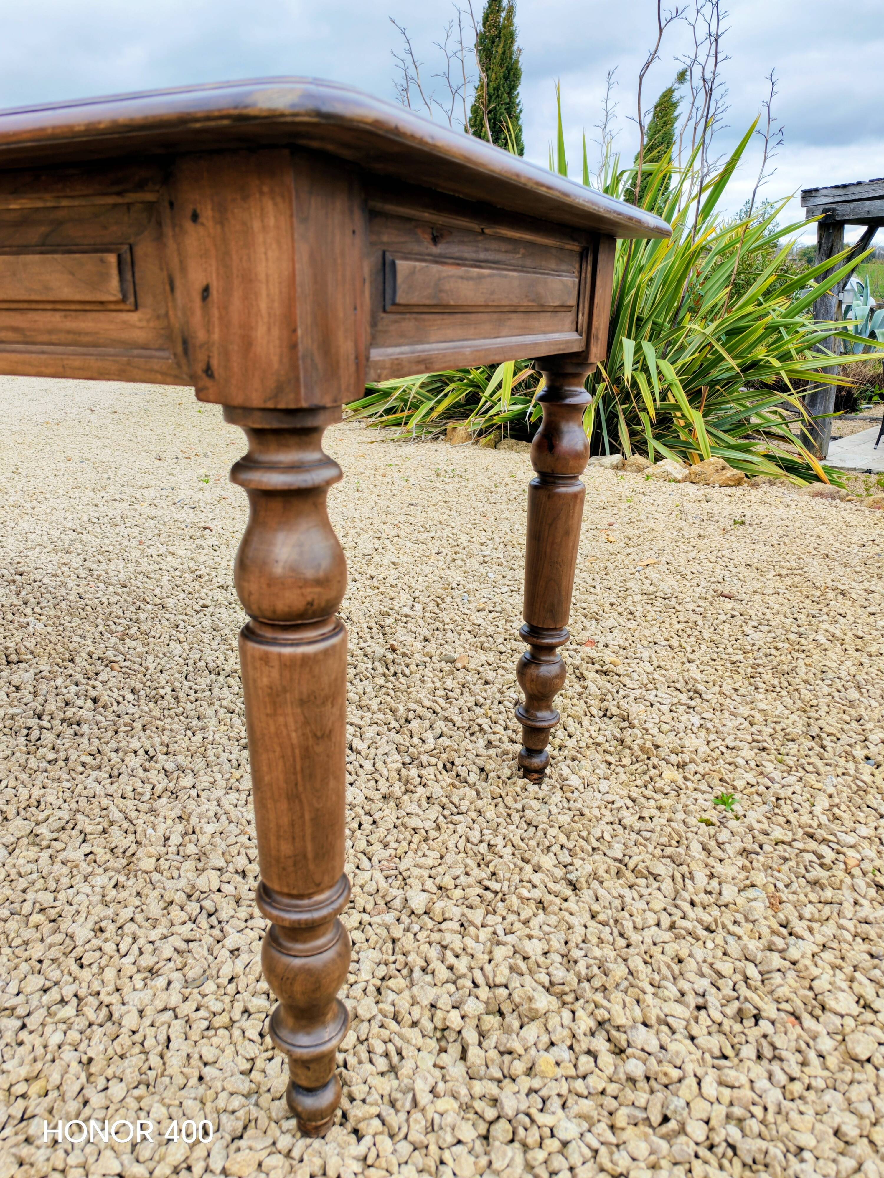 Old French farmhouse table in walnut with turned legs.