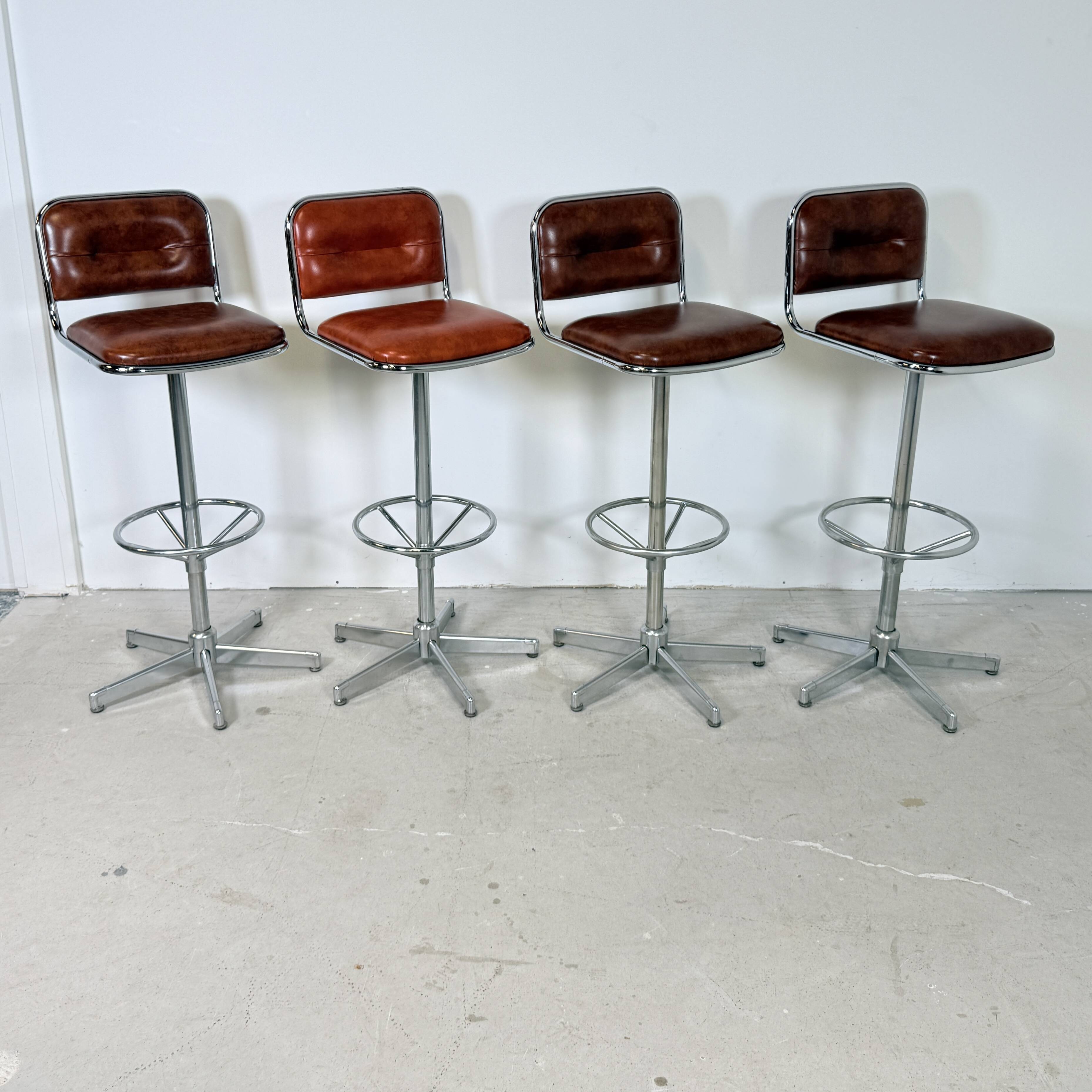 1970s chrome bar stools with cognac-colored faux leather upholstery