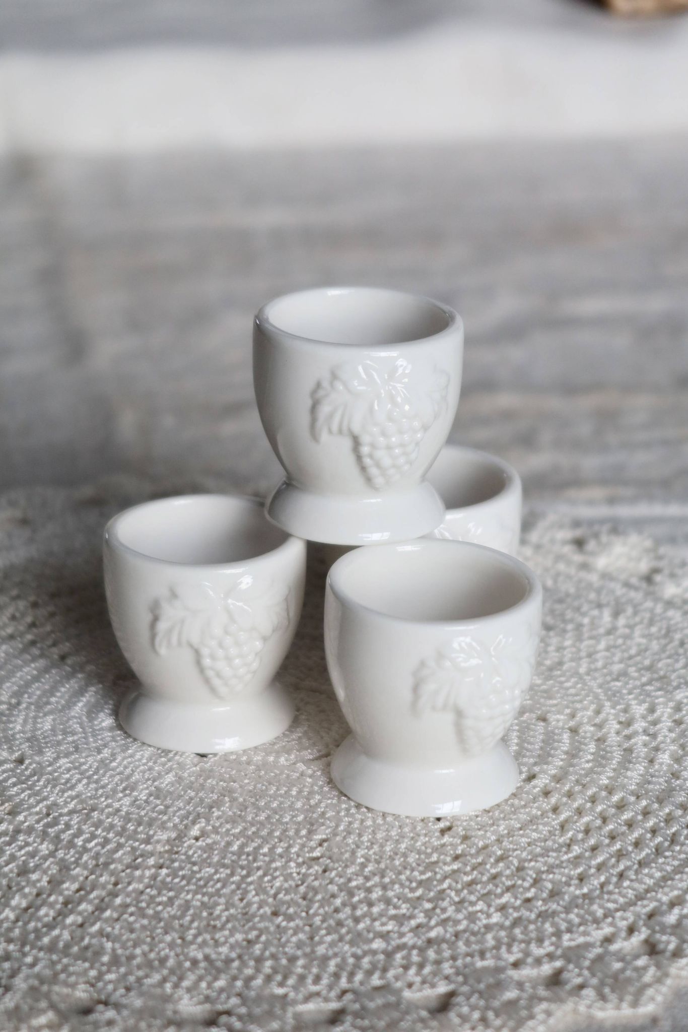 Vintage white porcelain egg cups with fruit motif.