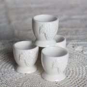 Vintage white porcelain egg cups with fruit motif.
