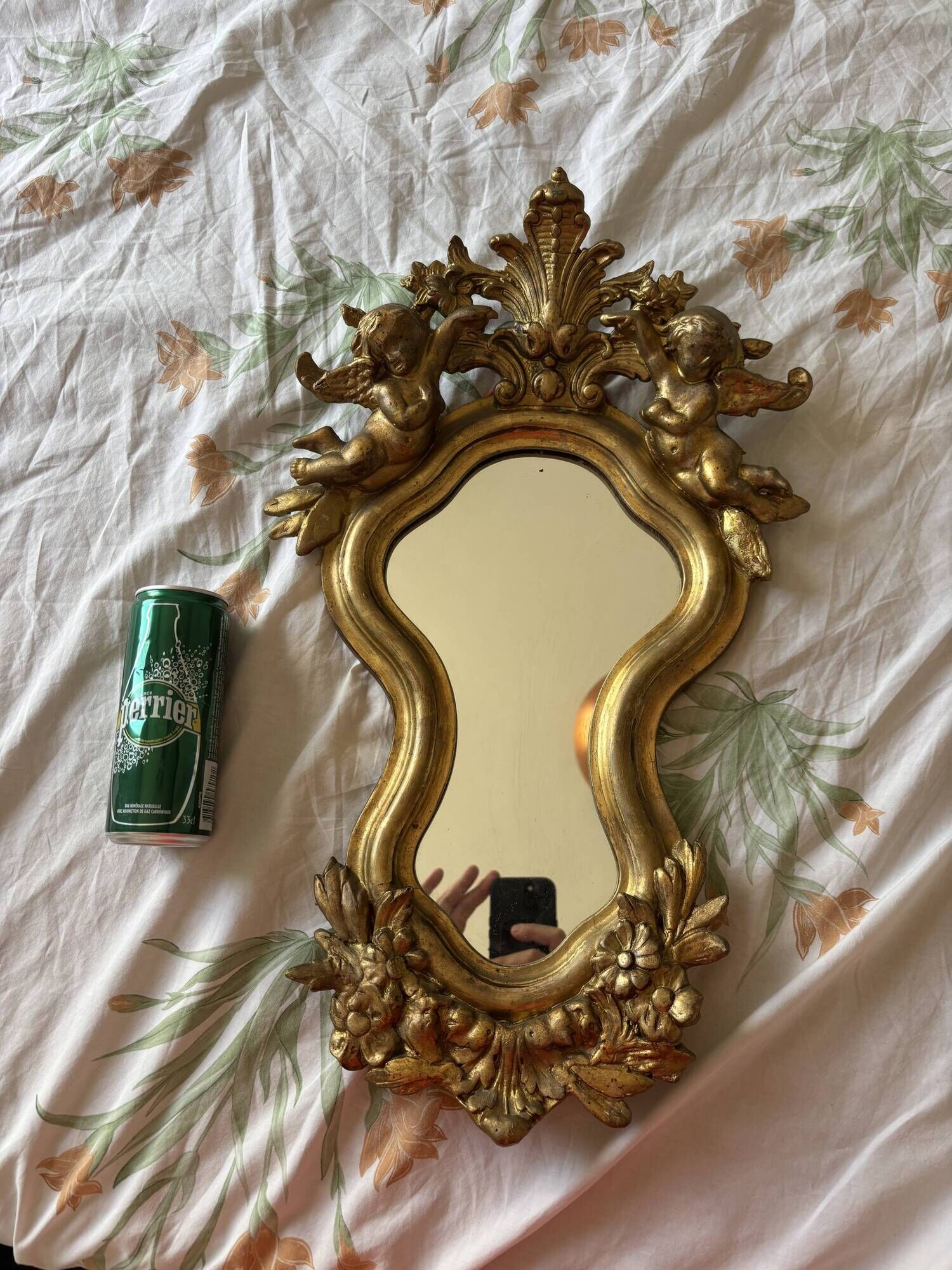 Antique rococo mirror with putti, gilded carved wood and stucco frame, 19th century.