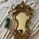 Antique rococo mirror with putti, gilded carved wood and stucco frame, 19th century.