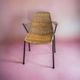 Vintage wicker chair with black steel frame and armrests