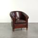 Vintage sheepskin club armchair with decorative nails and black piping