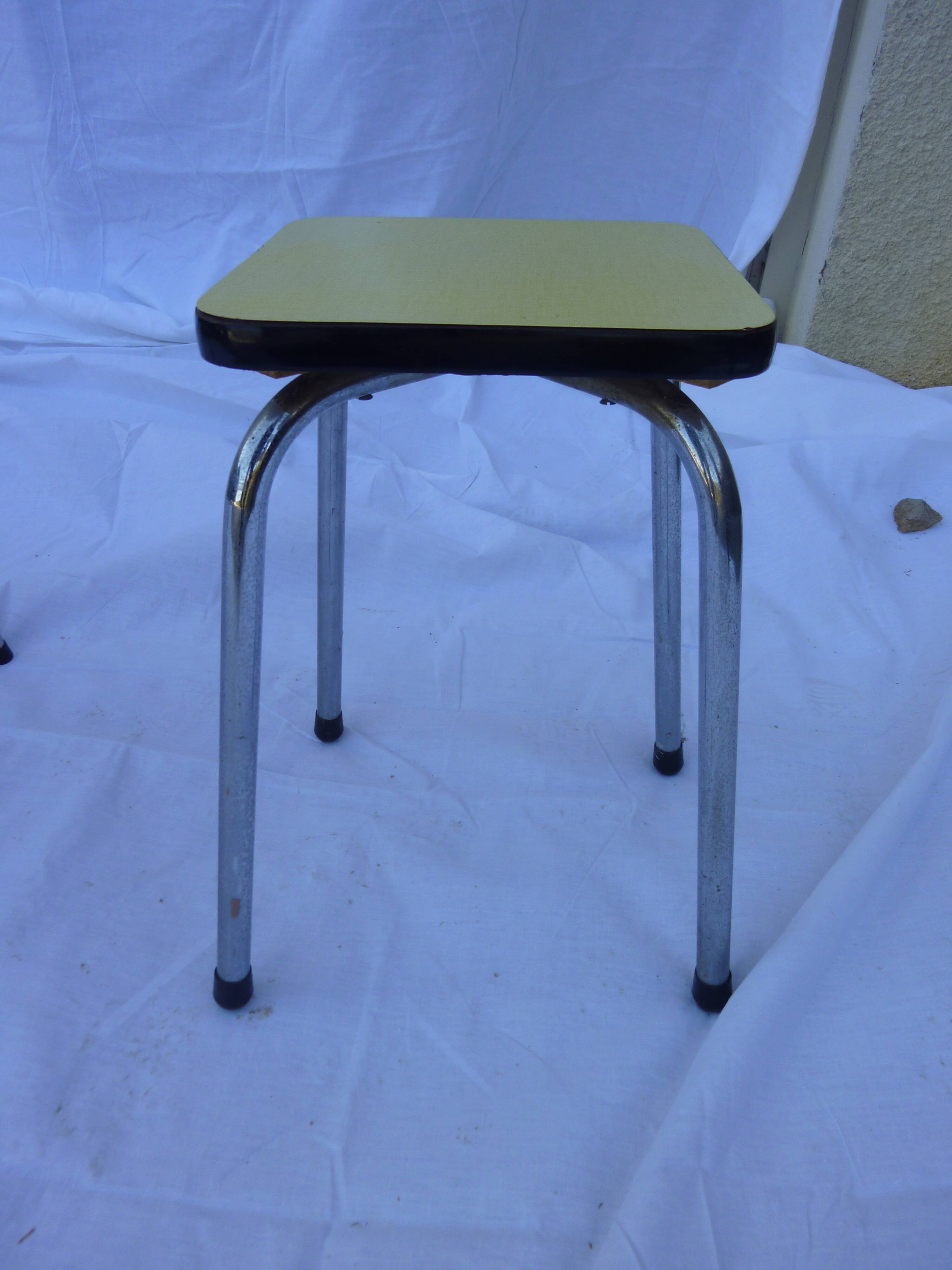 Two chairs and a yellow and blue stool in formica