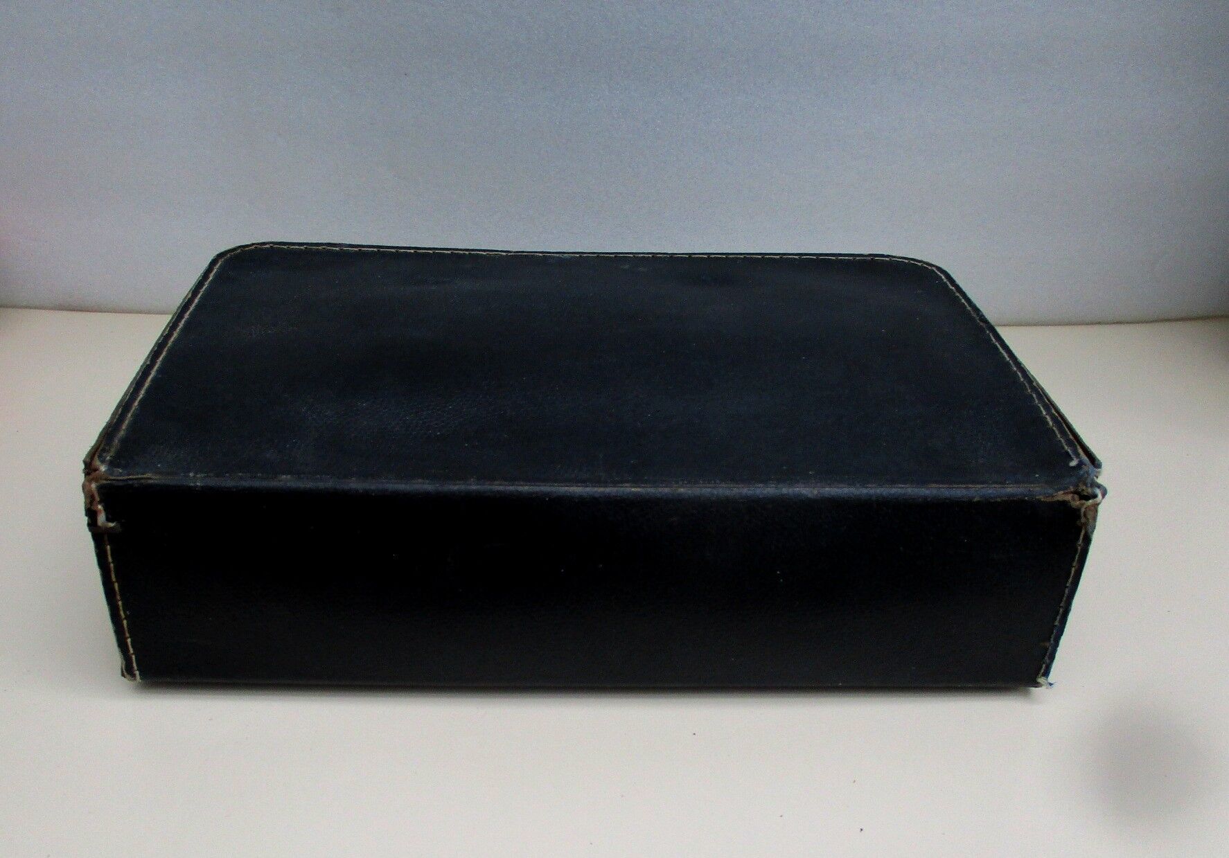 Small suitcase in old navy blue cardboard