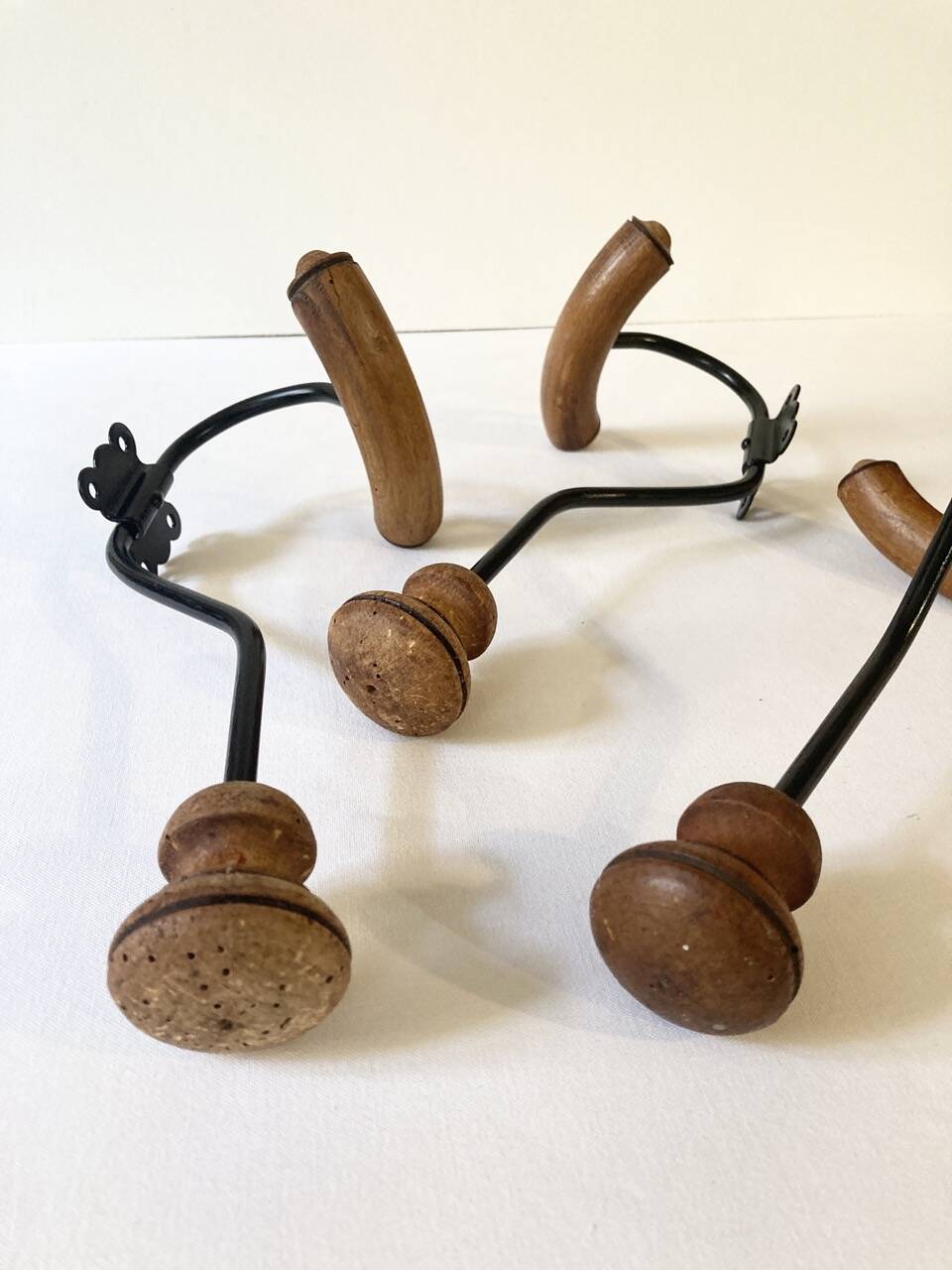 Trio of antique wooden and metal coat hooks