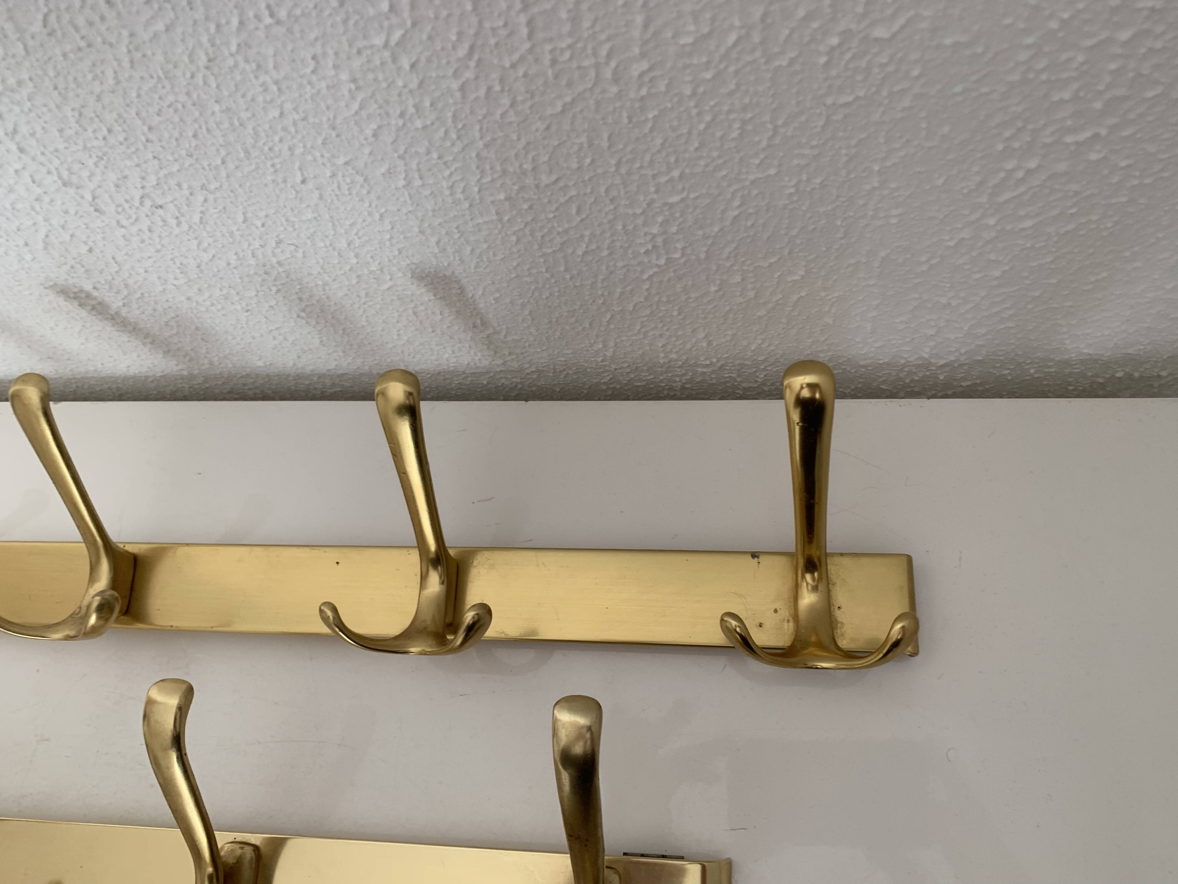 Three vintage 1960s gold coat racks with 4, 3 and 2 hooks