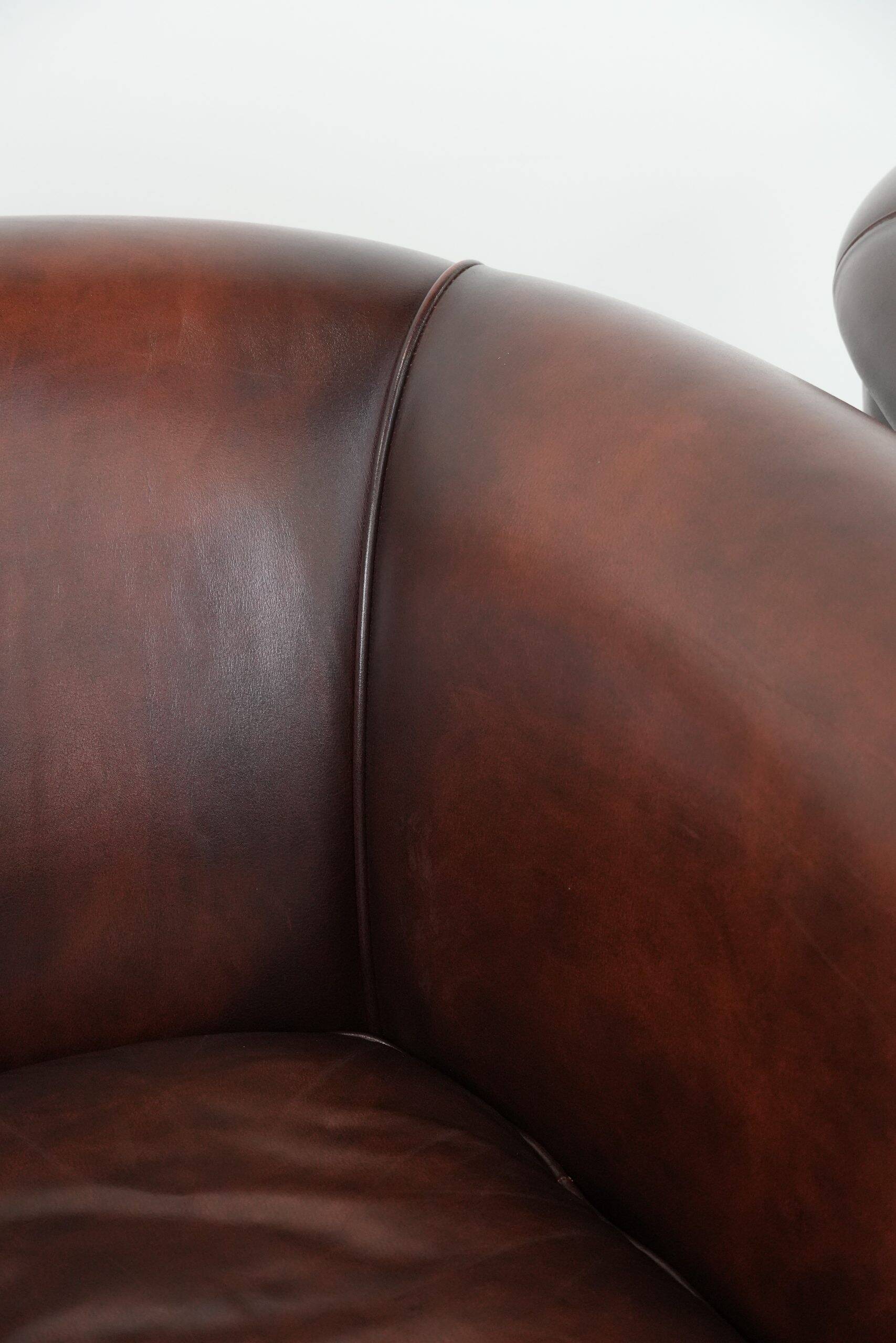 Set of two cow leather club armchairs in a luxurious red/brown colour