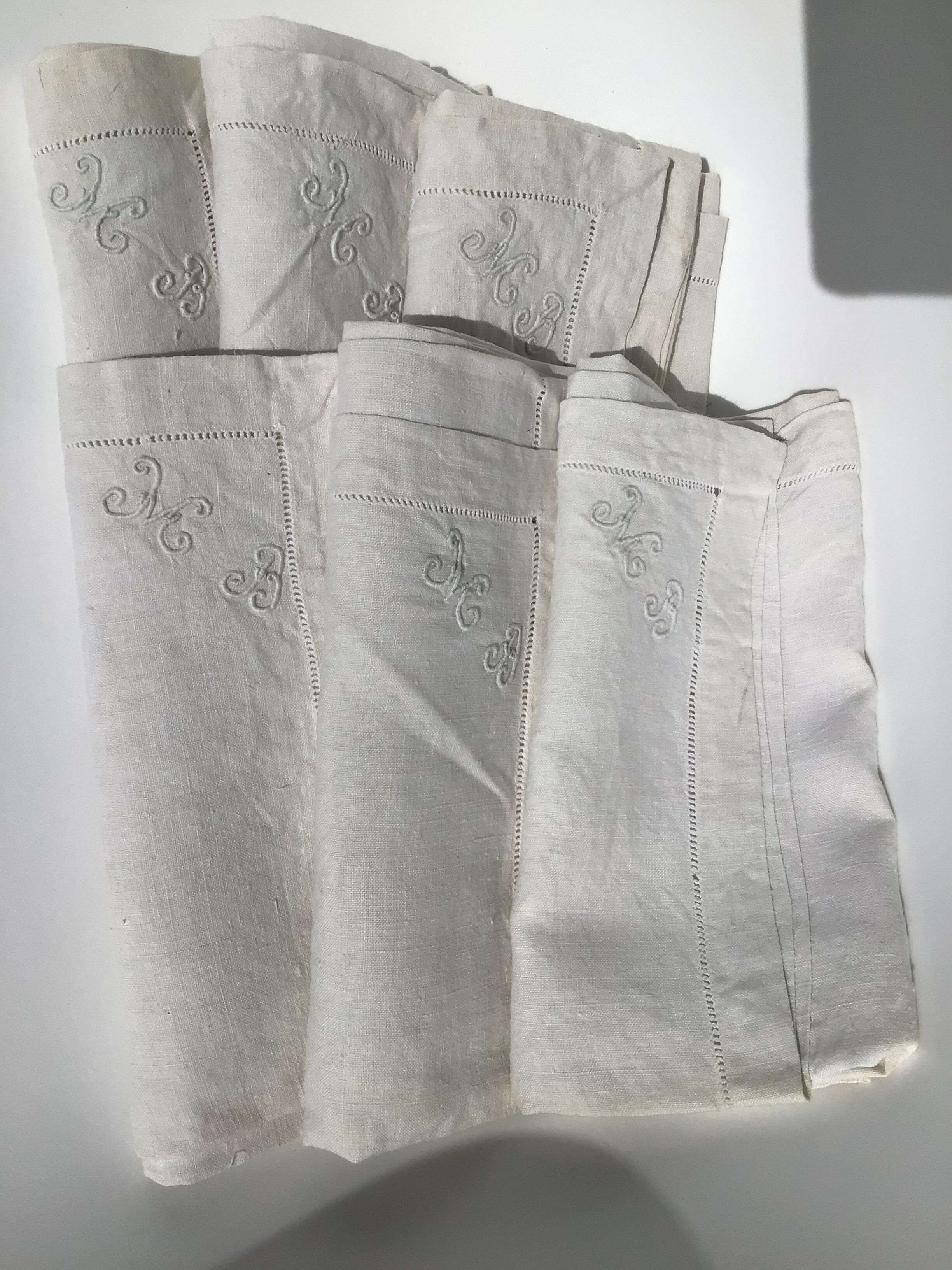 6 square linen napkins with hand-embroidered initials in the corner.