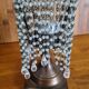 Metal candle holder with white glass tassels