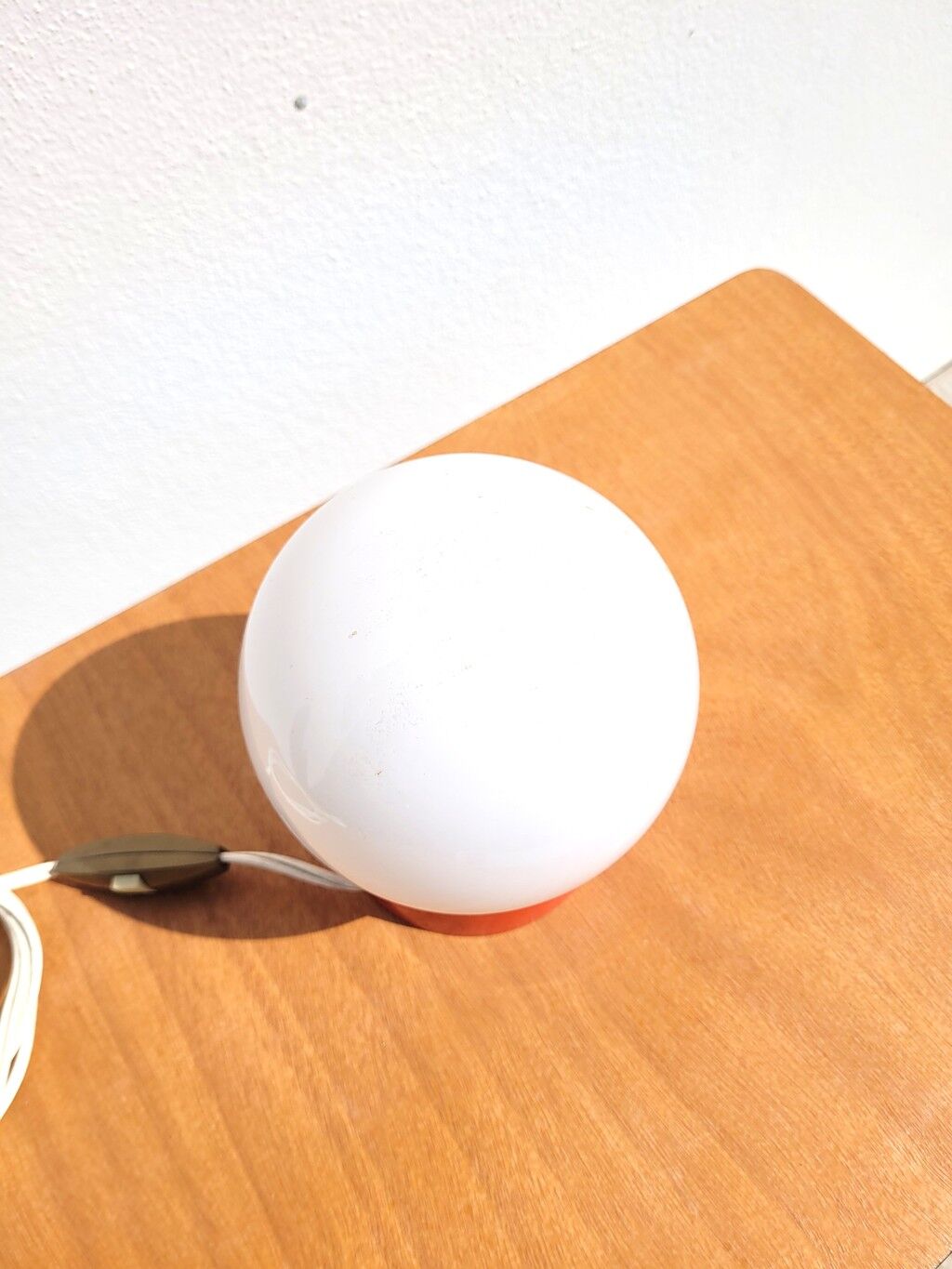 Small vintage opaline ball lamp with an orange base.