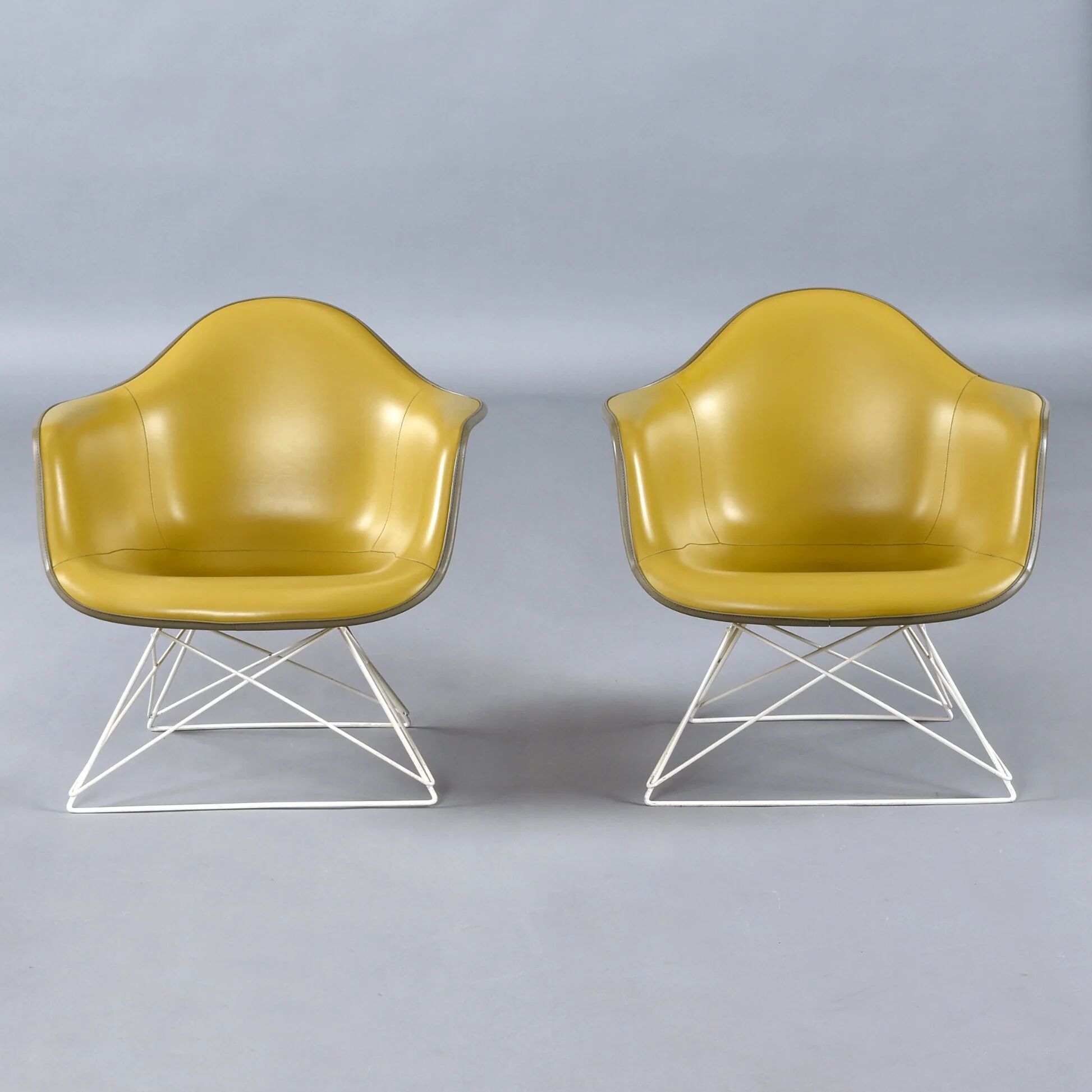 Paire de chaises coque LAR Eames pour Herman Miller avec des coussins en Naugahyde jaune.