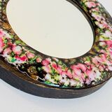 Vintage enameled metal hand mirror on wood