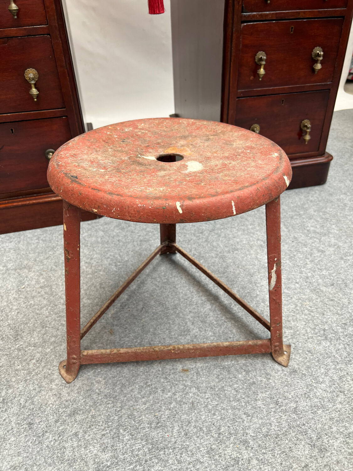 Red tripod industrial metal stool