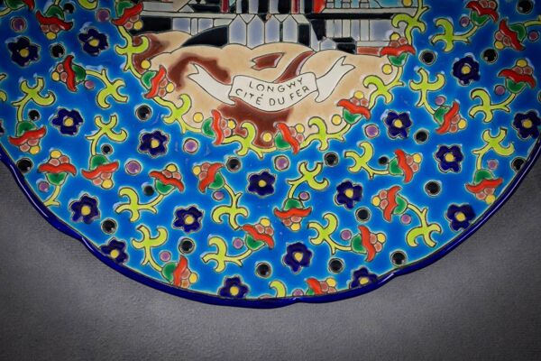 Assiette Longwy émaux polychromes décor cité du fer