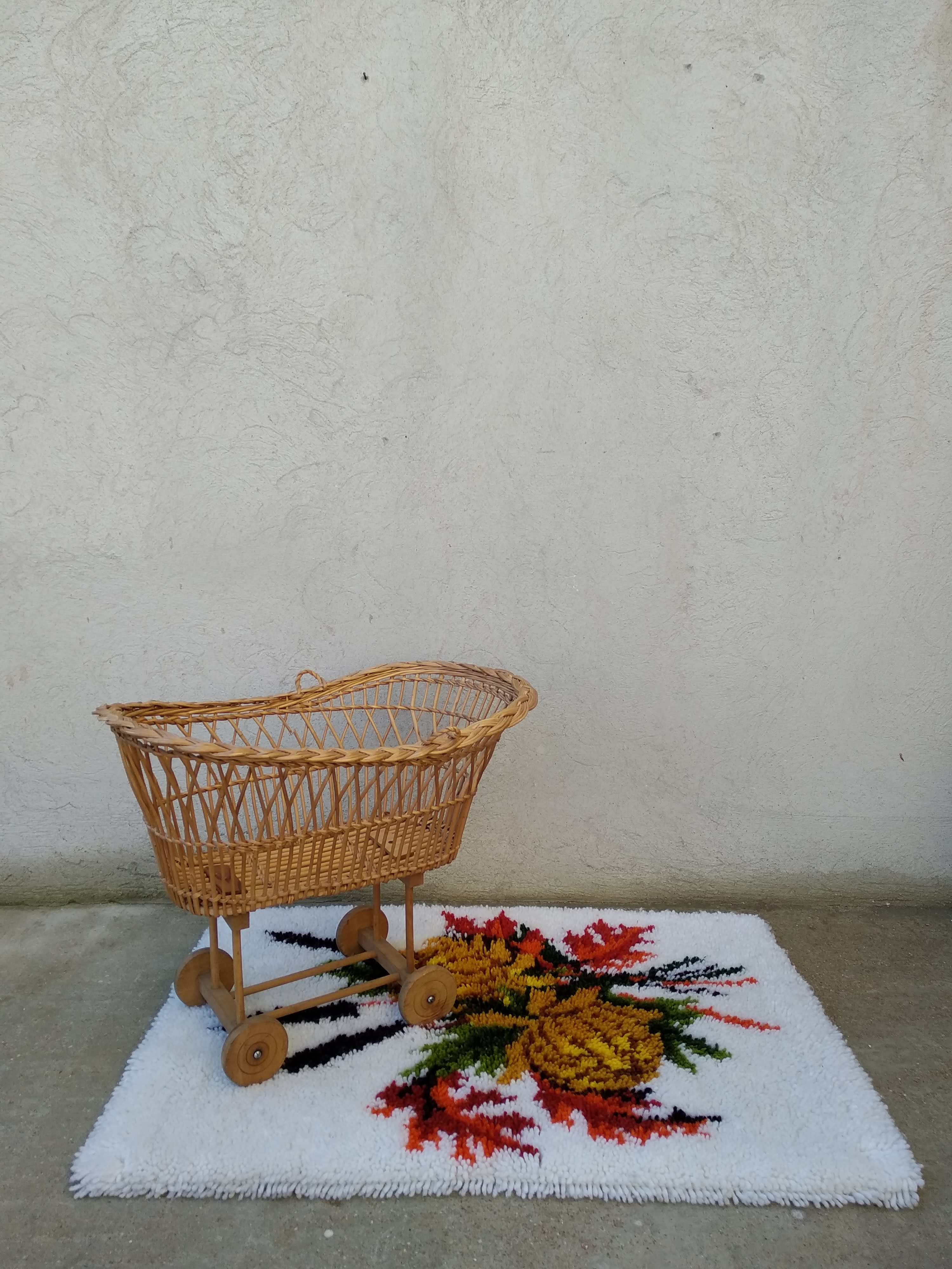 Rattan cradle for doll on vintage wheels