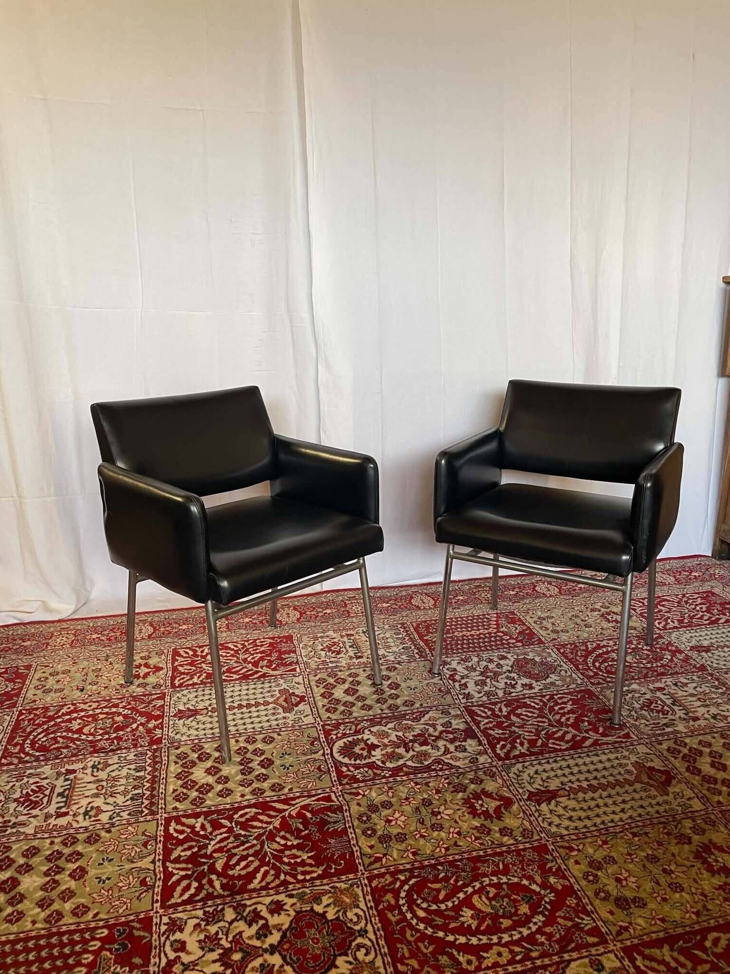 Pair of vintage armchairs in black faux leather and chrome metal.