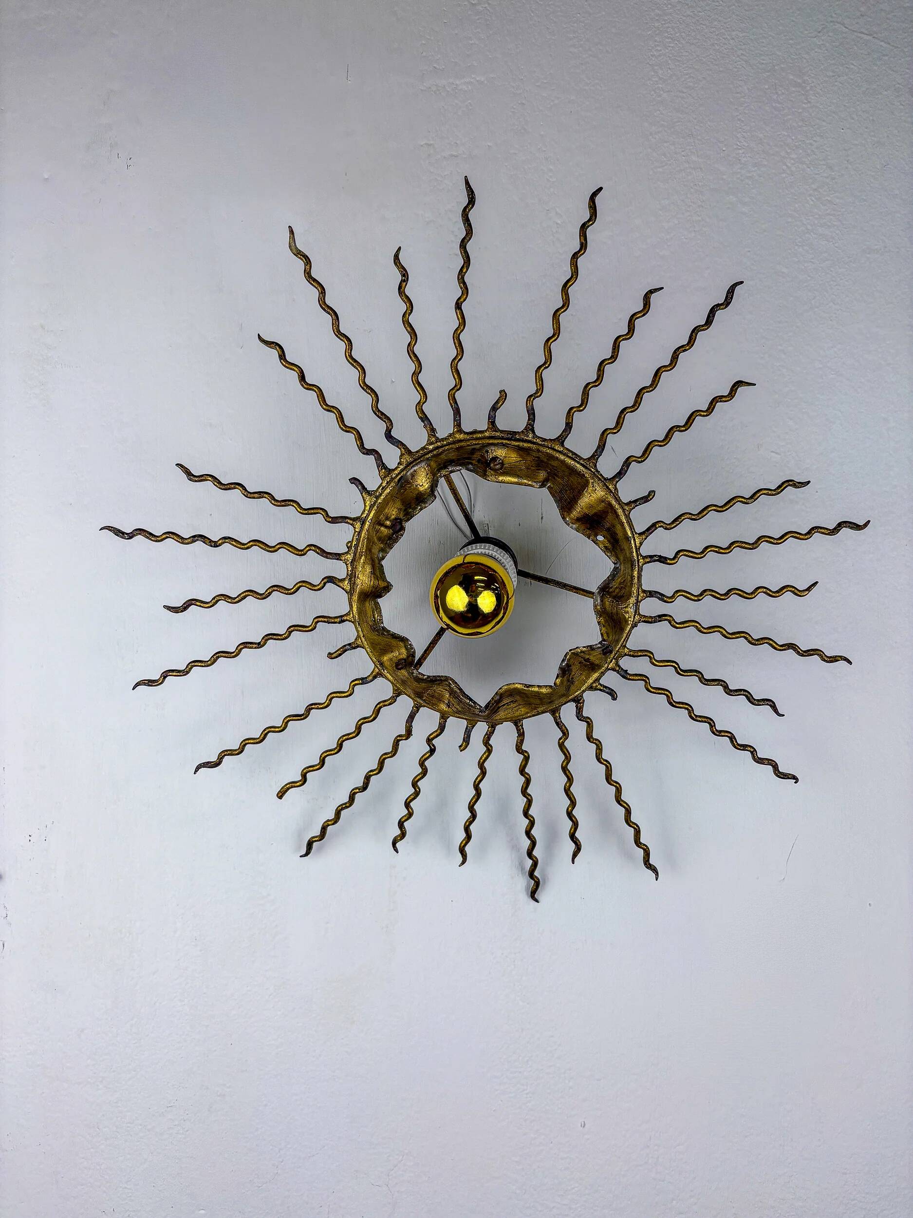 Spanish sunburst ceiling light – gilt iron rays & exposed bulb, 1960s