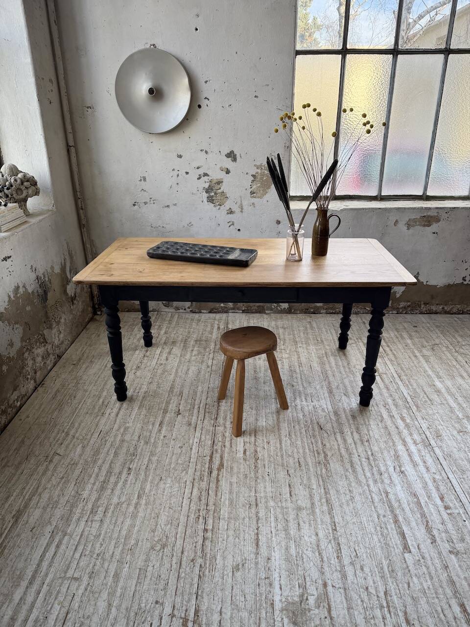 Oak farmhouse table with turned black legs.