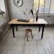 Oak farmhouse table with turned black legs.