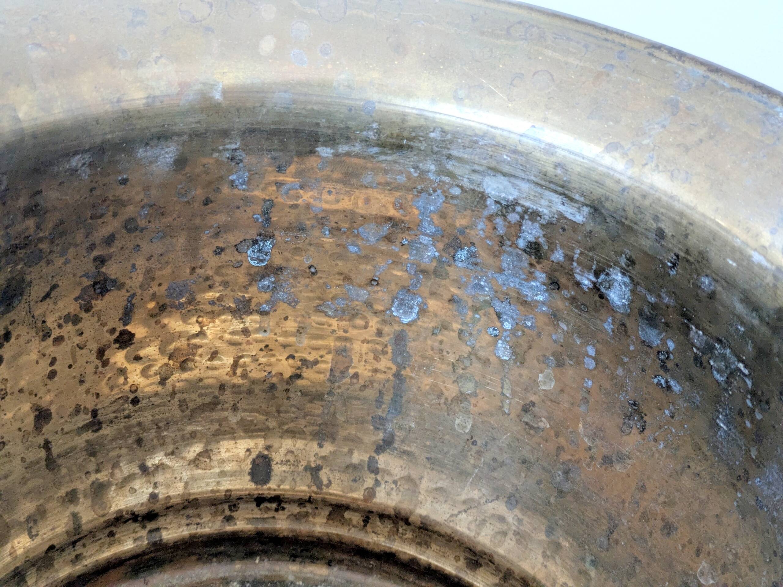 Vintage round cache-pot in hammered brass with decorative handles and patina.