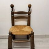 Low fireplace chair in the style of Charles Dudouyt – wood and straw seat.