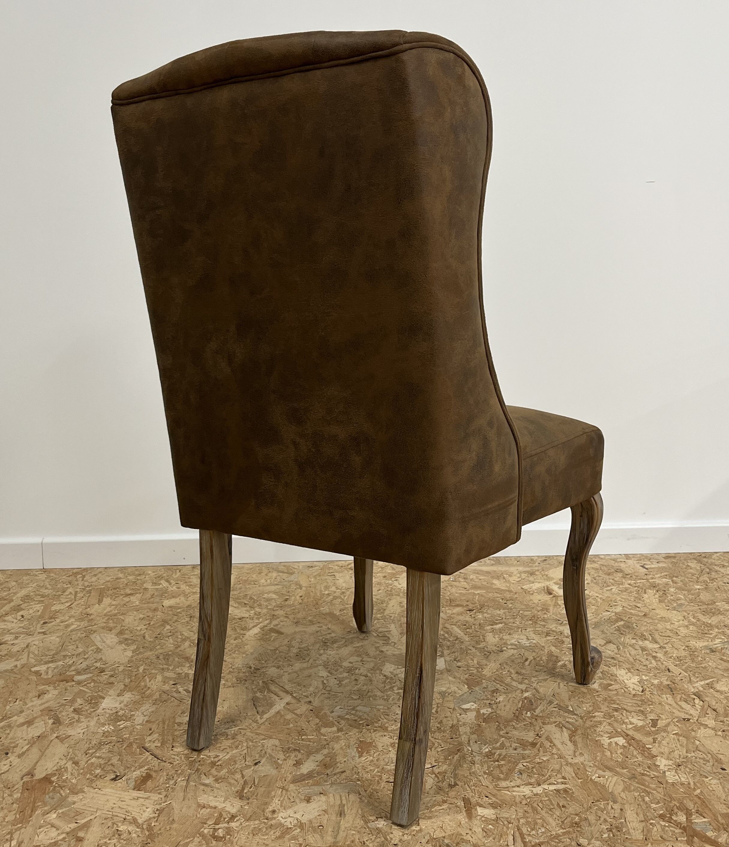 Upholstered armchair in brown imitation leather