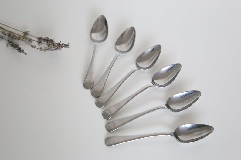 Serving small silver metal notched spoons