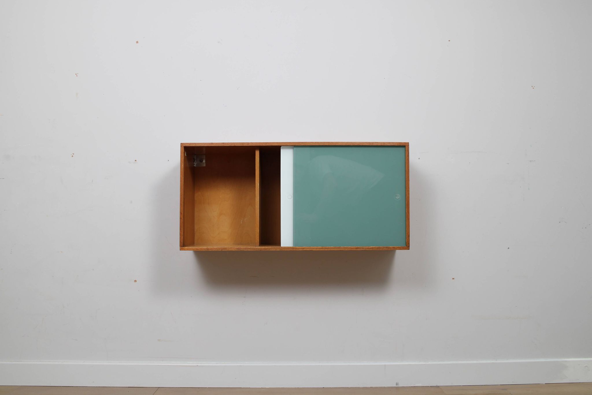 A vintage mid century wall hung bookcase/cabinet with glass sliding doors