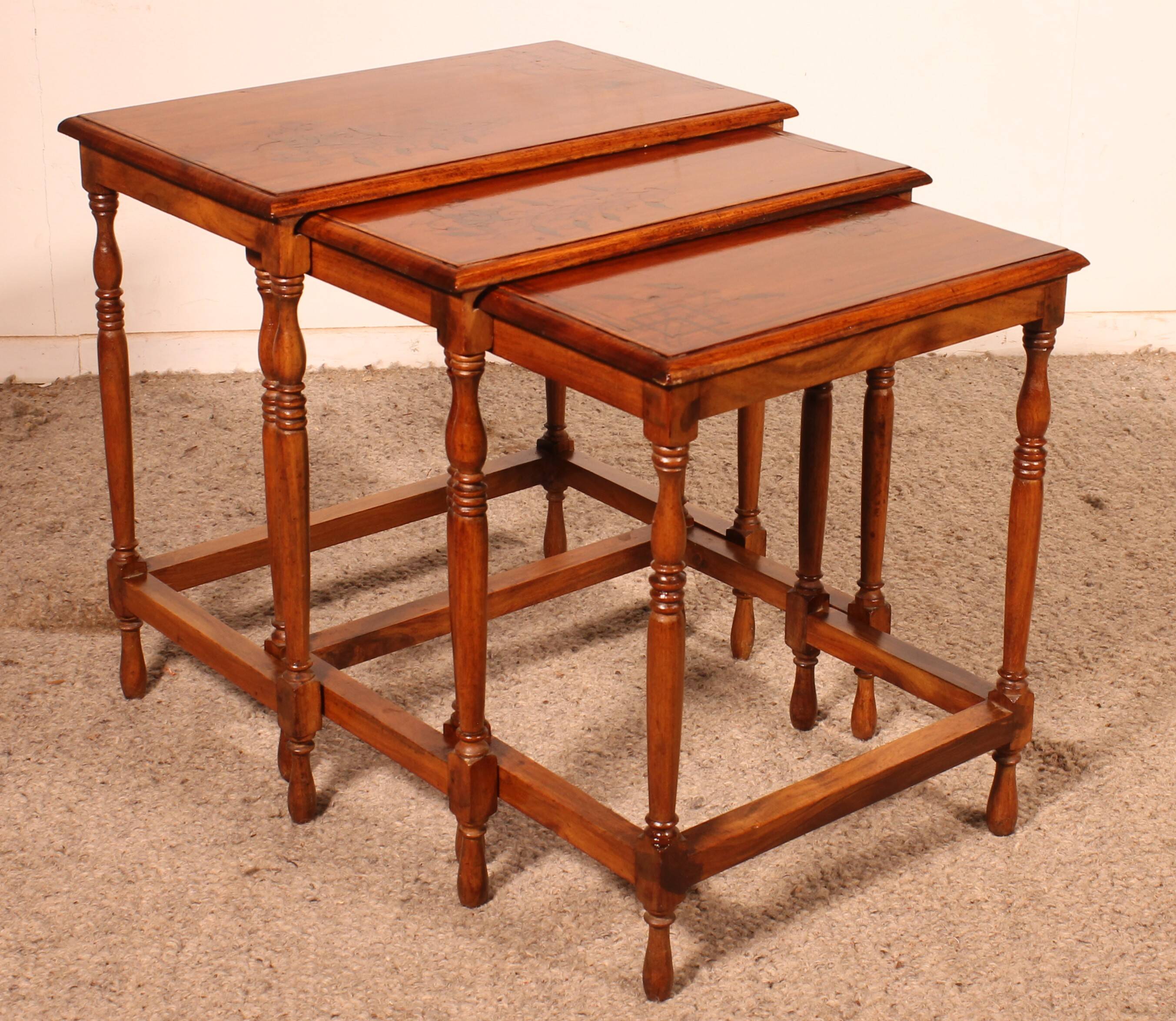 Nested tables in satin wood with brass inlays.