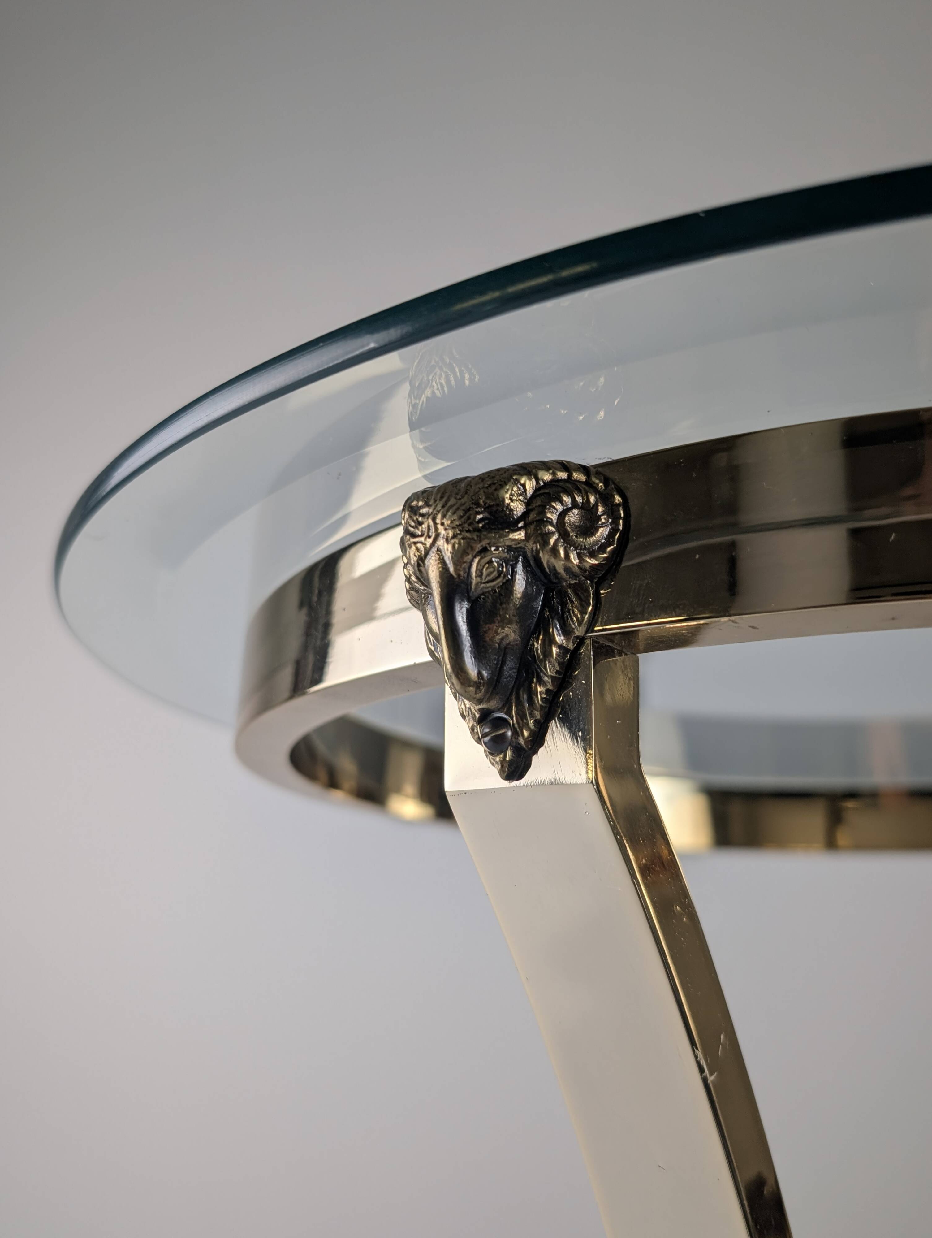 Neoclassical side table in brass and bevelled glass with ram's heads, 1970s.
