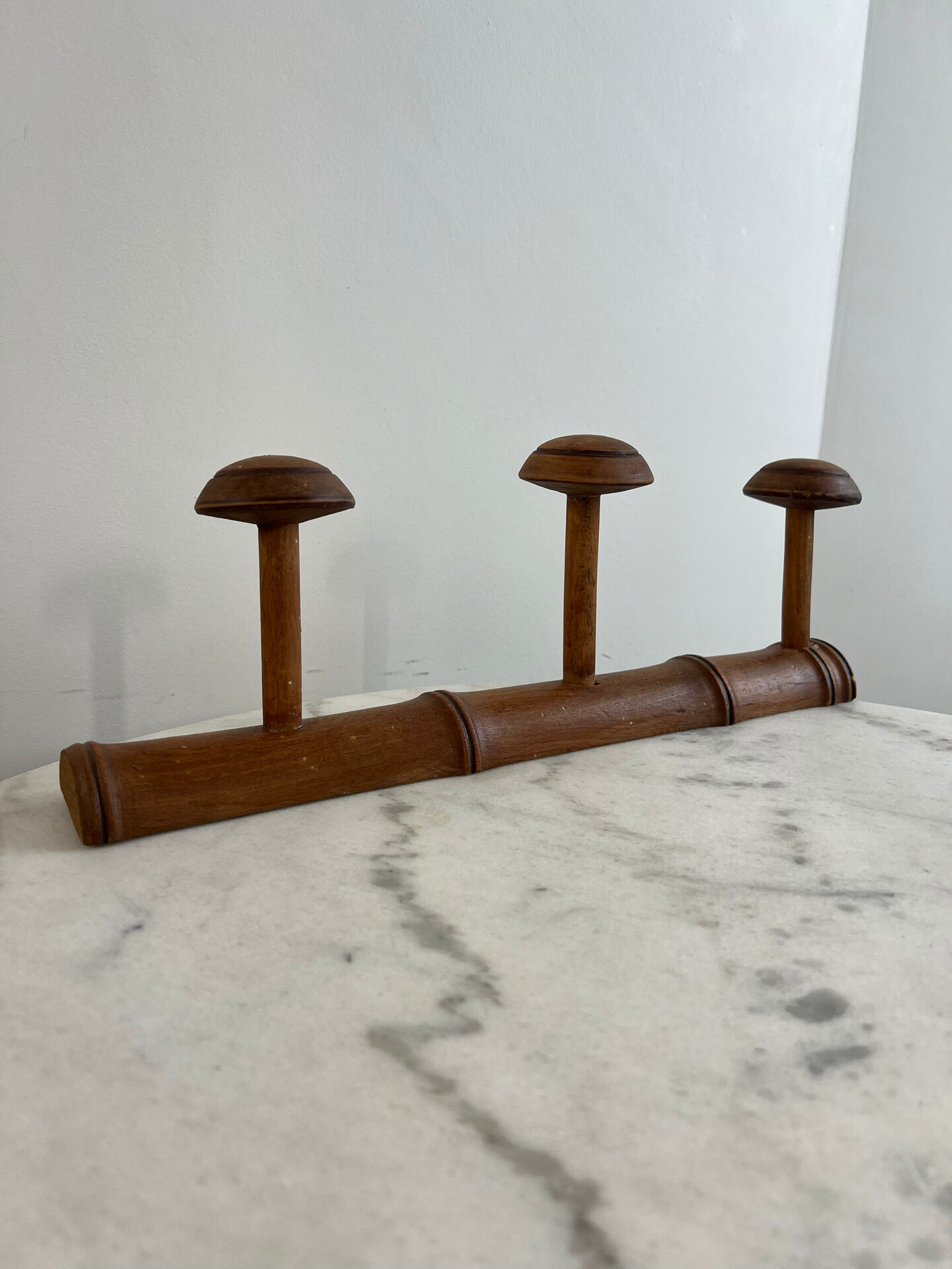 Wooden coat rack with three ball hooks.