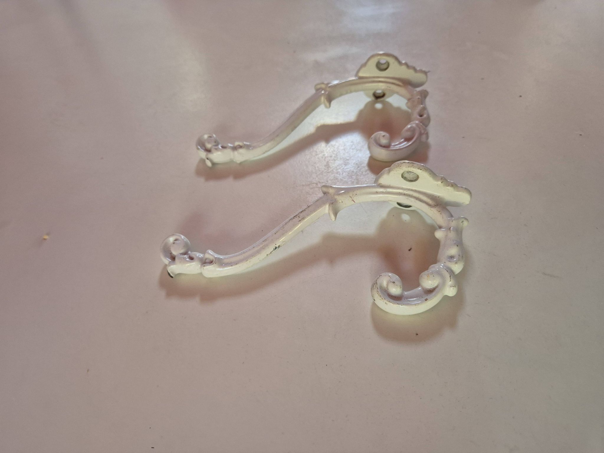 set of 2 vintage white cast iron hooks, small paint chips from the year