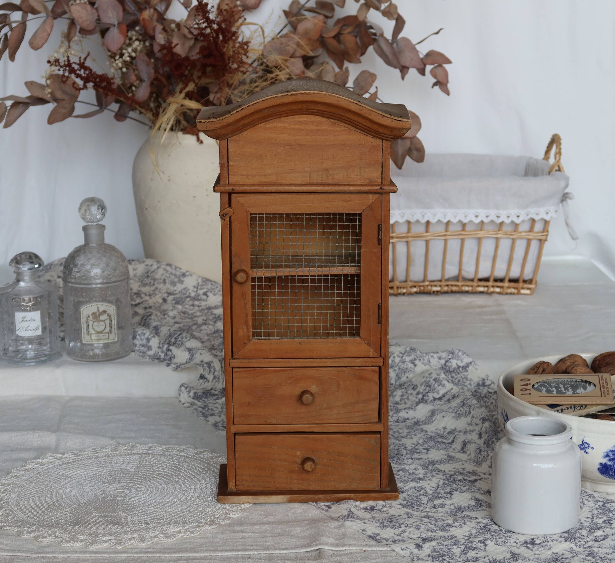 Vintage wooden shelf with drawers and mesh door.