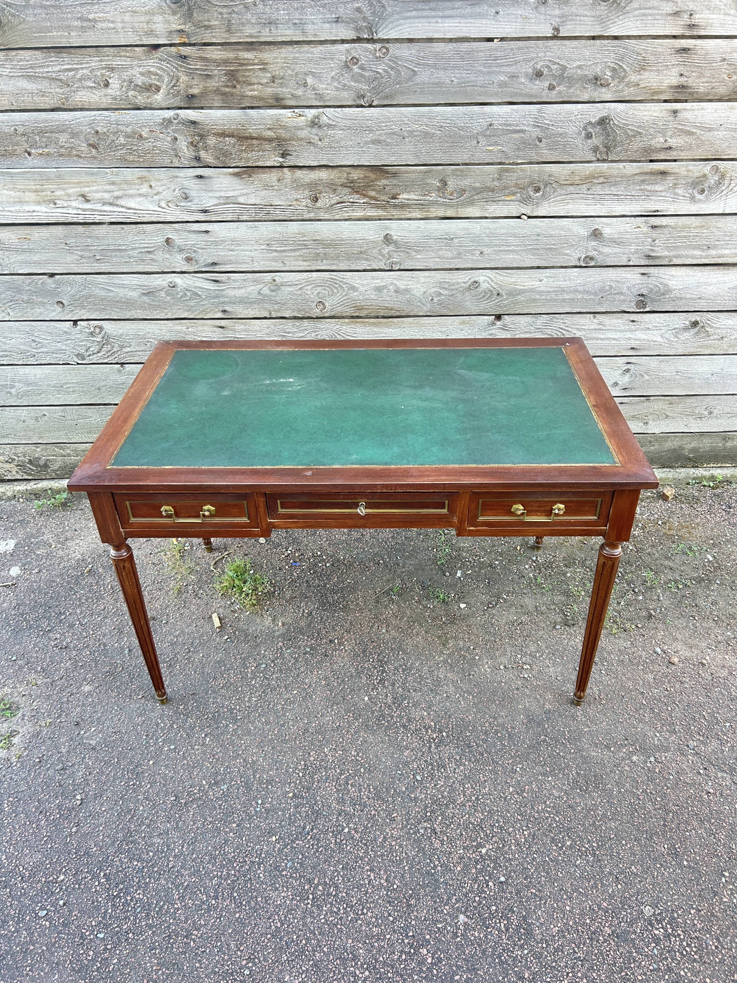 Louis XVI style desk in mahogany with a green leather top.