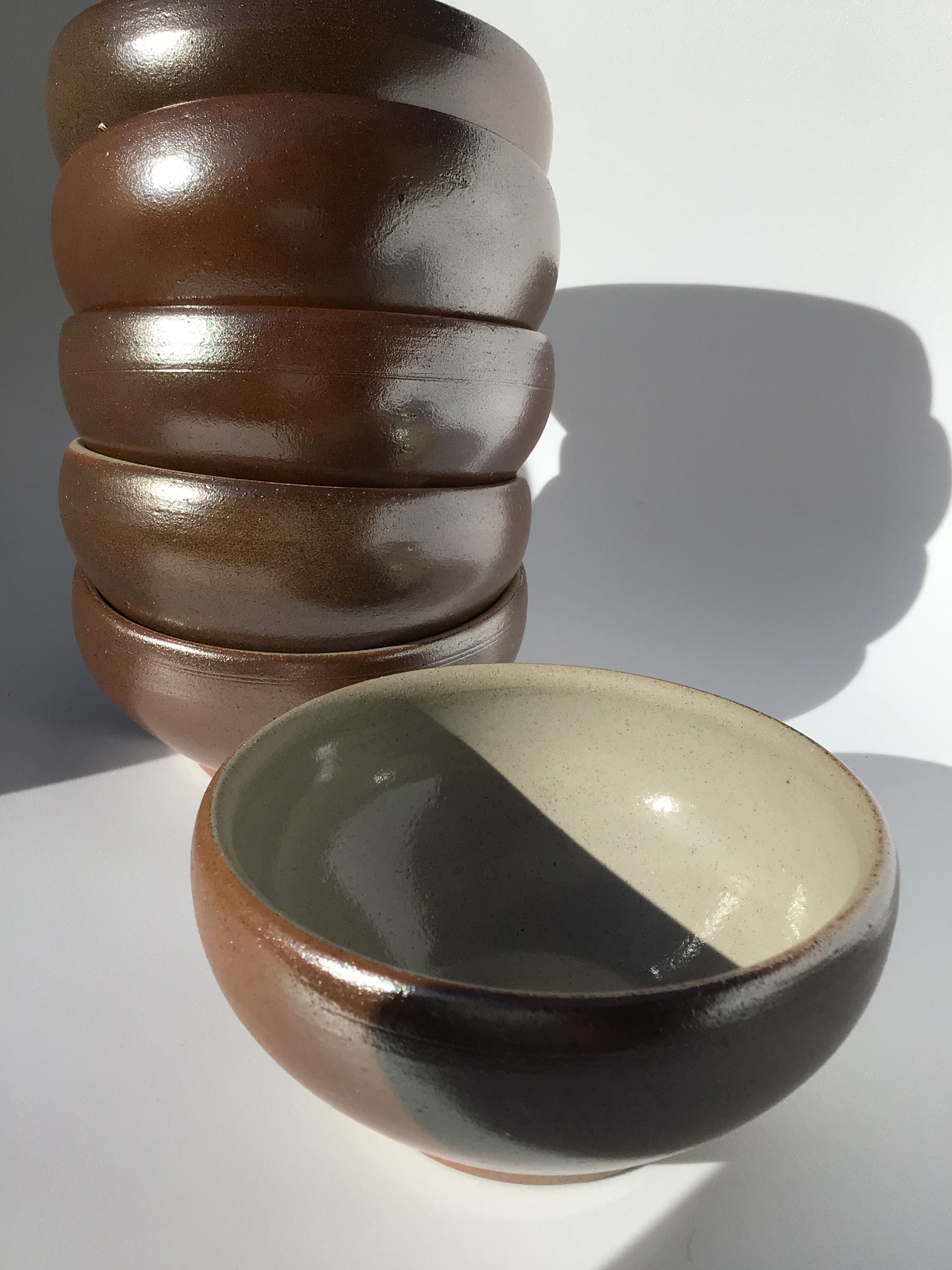 6 iridescent brown sandstone bowls inside grey