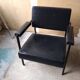 Fauteuil année 70 . Skaï noir et tube carré acier traité noir. Bon état du skaï