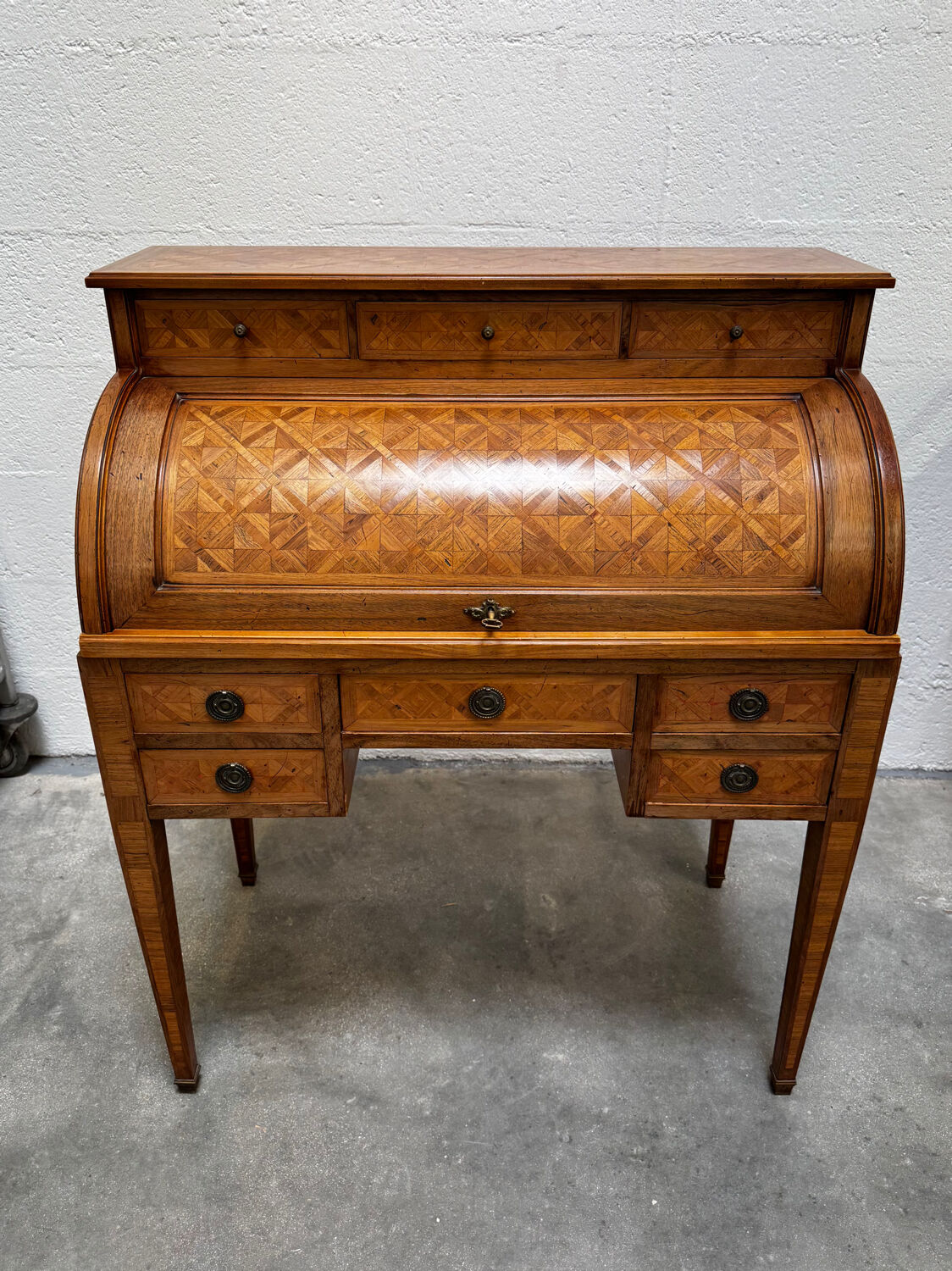 Cylinder desk with marquetry featuring a crosshatch design.