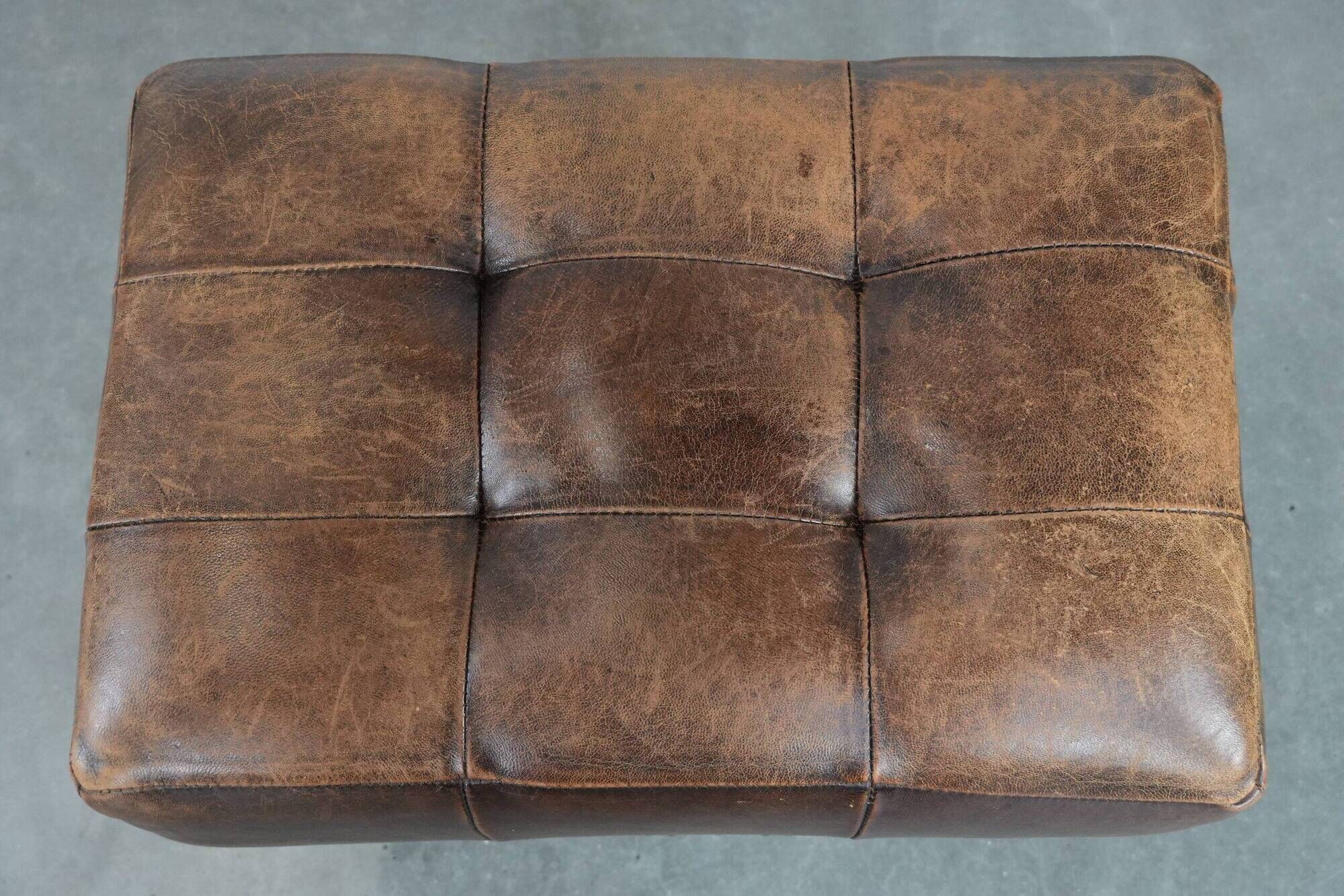 Beautiful sheepskin ottoman on high legs and beautiful warm colours