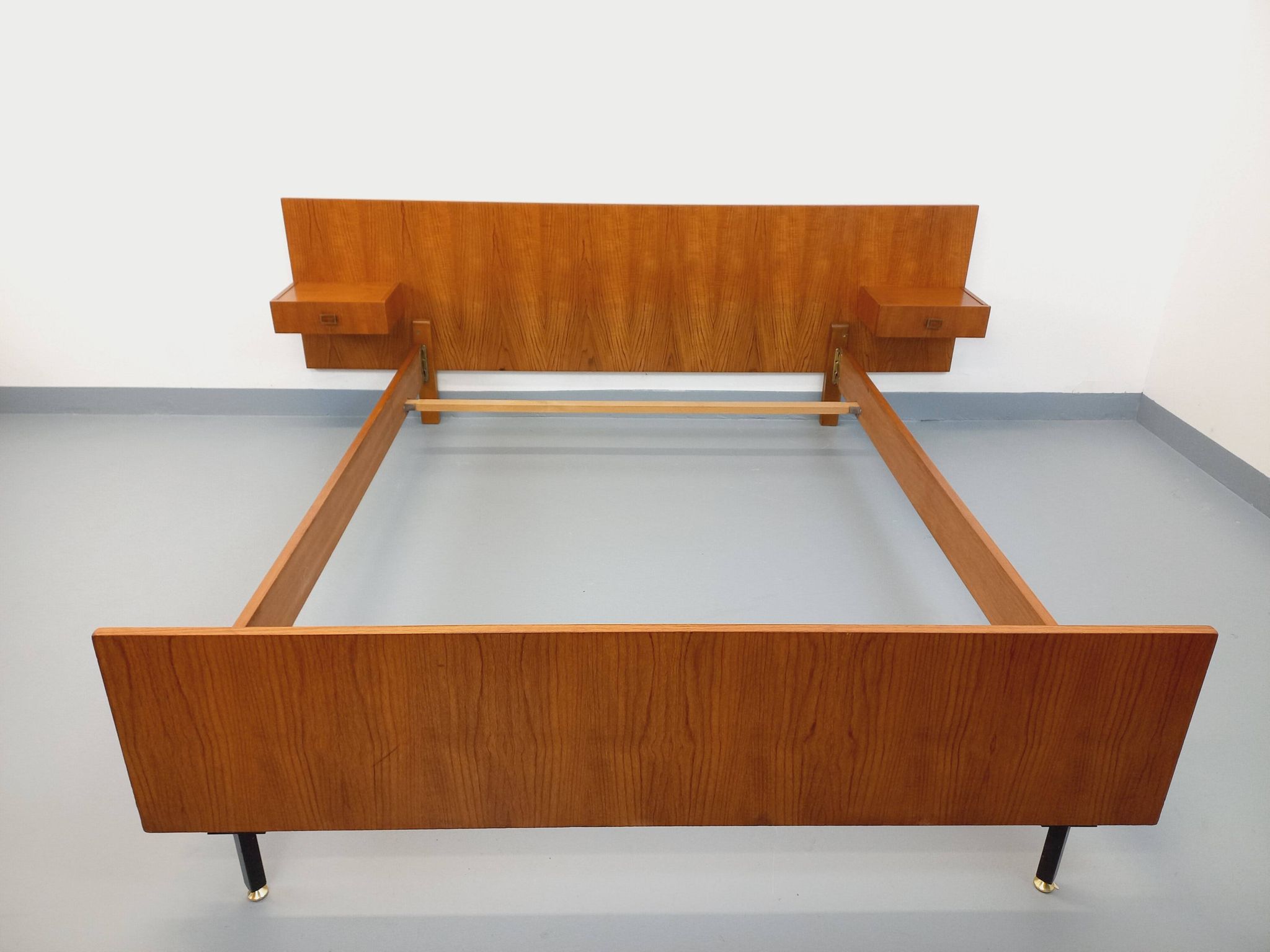 Double bed vintage modernist in teak and black metal from the 1960s with bedside tables.