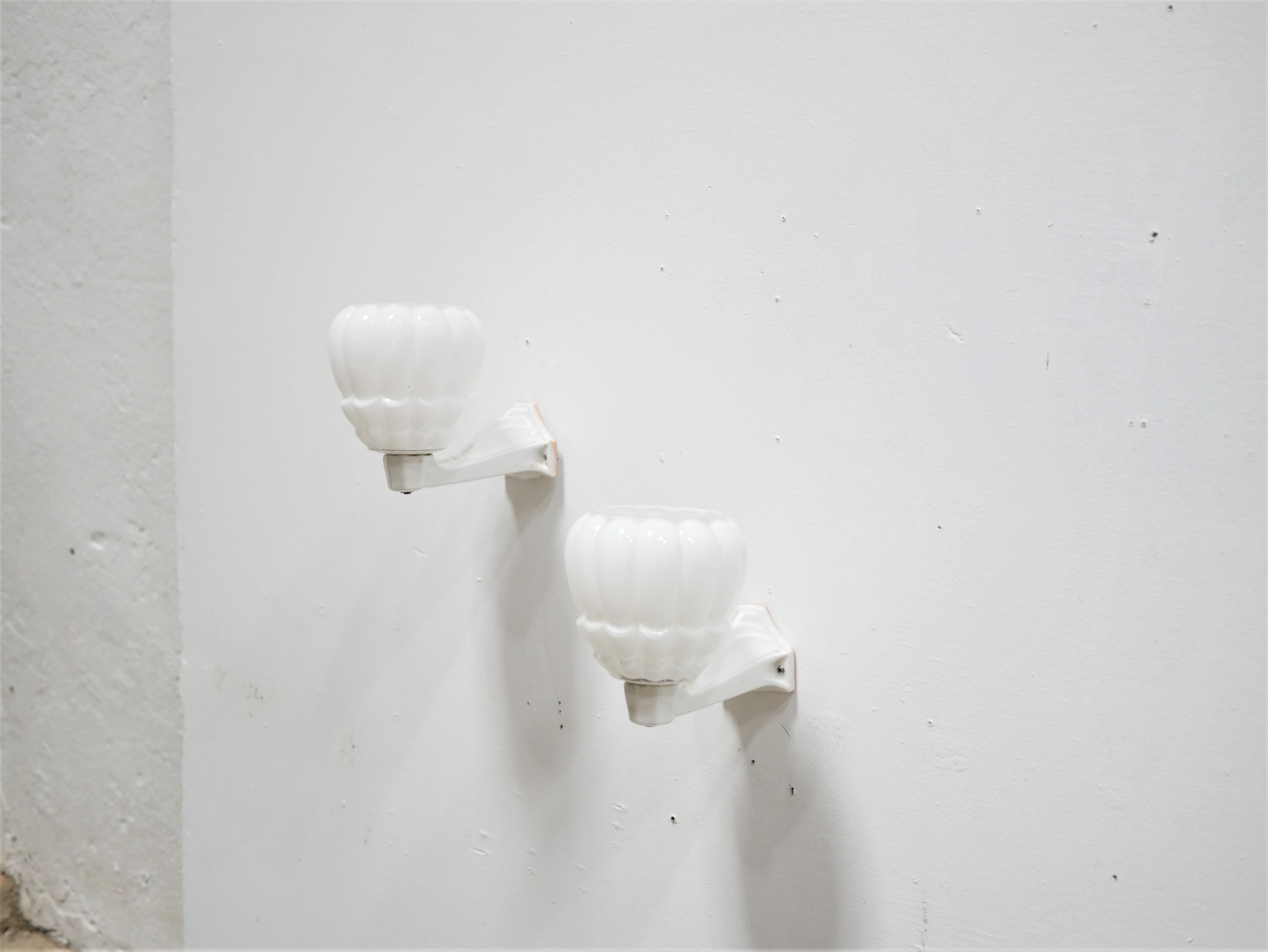 Pair of art deco porcelain and glass wall appliques