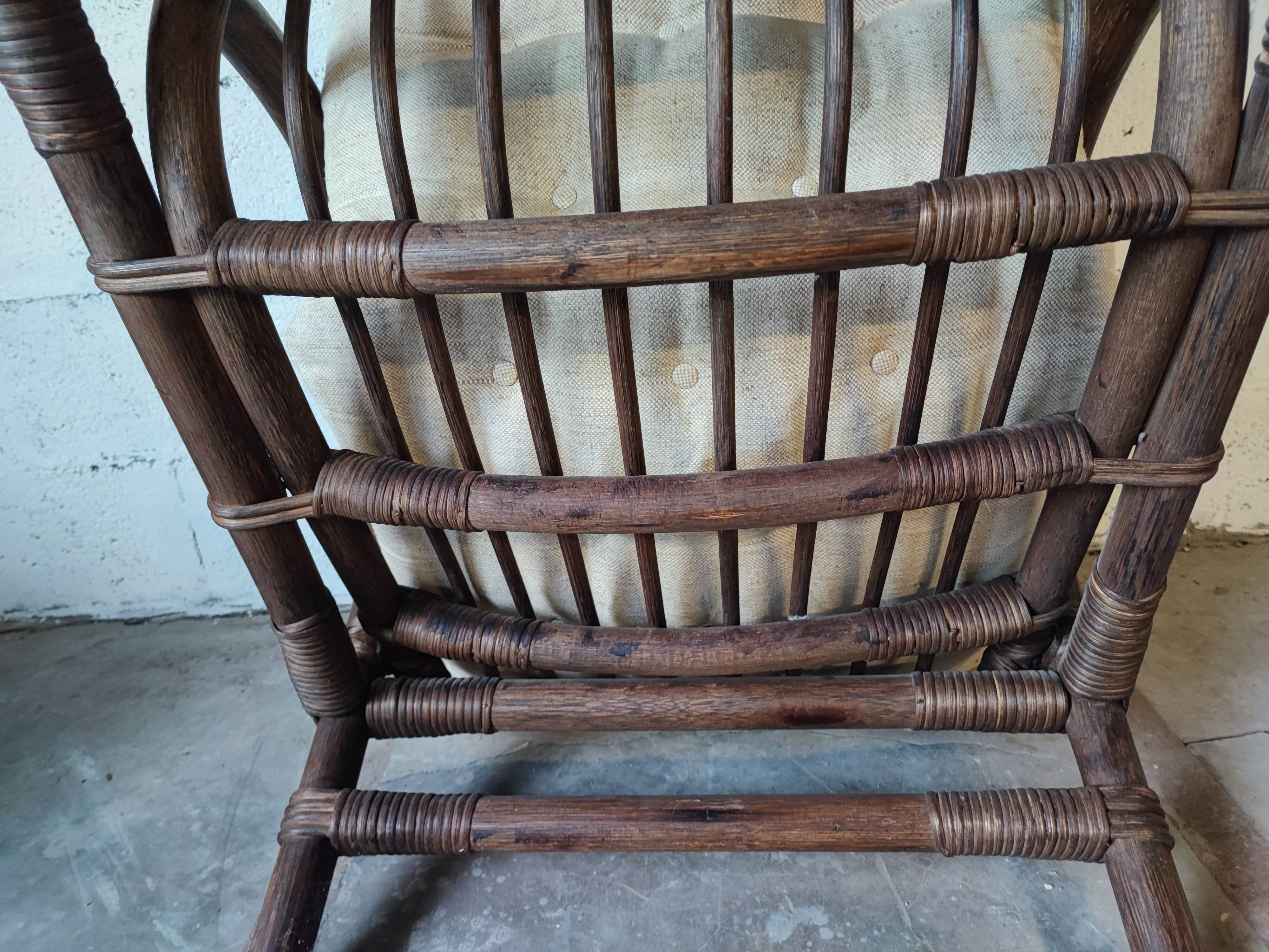 Relaxed armchair in bamboo and rattan with its small side table. Beige linen cushion.