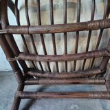 Relaxed armchair in bamboo and rattan with its small side table. Beige linen cushion.