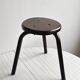 Dark brown metal stool, minimalist three-legged design