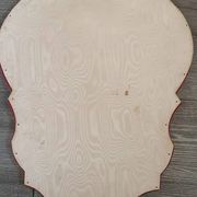 Vintage mirror with a scalloped shape in burgundy velvet and a golden trim.