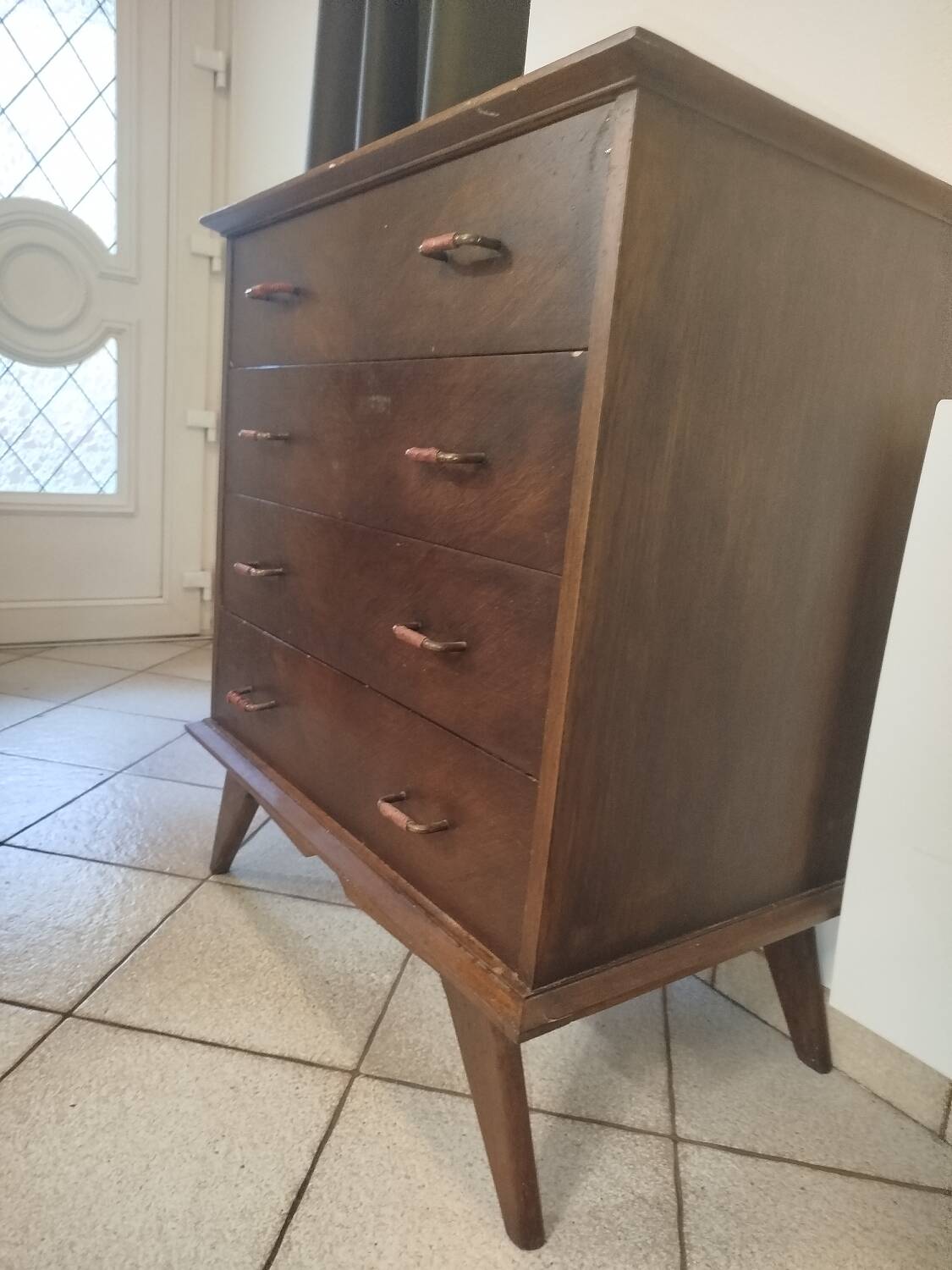 Vintage chest of drawers from the 1950s with wooden legs and a design feature.