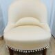 Pale pink upholstered armchair with wooden legs.