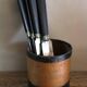 A set of 8 knives with black wooden handles and bolsters.